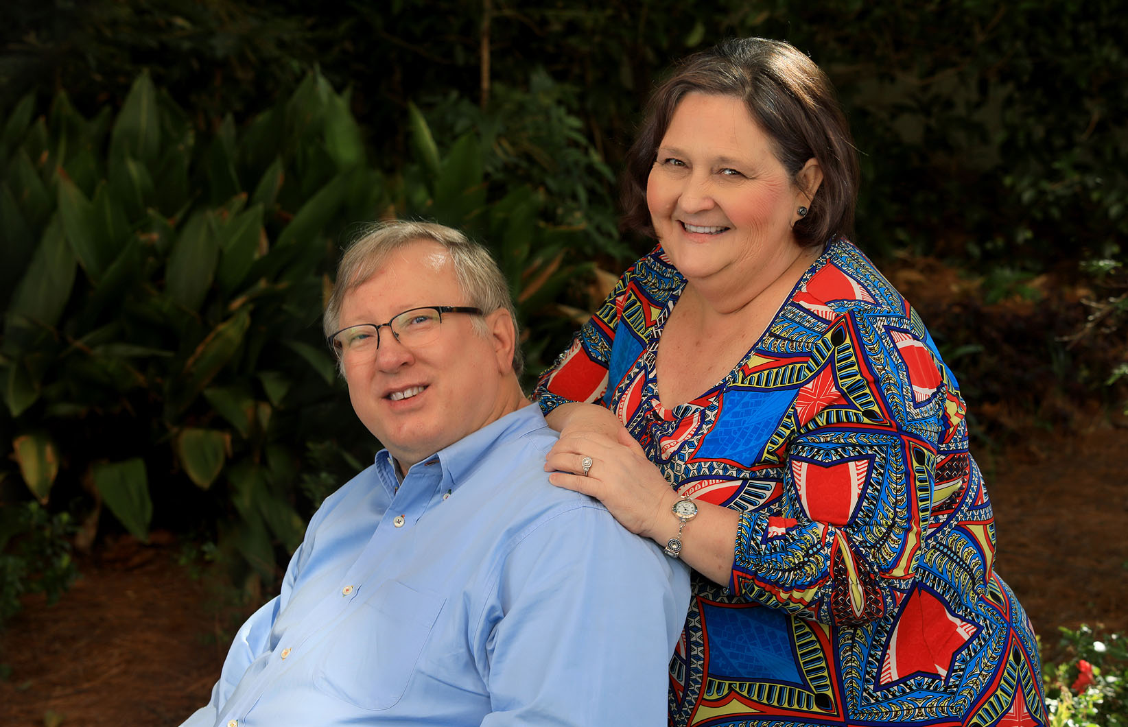 Donna and Murphy Peele in a garden, posed in front of cast iron plants.
